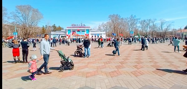 Взрослые с детьми гуляют по площади